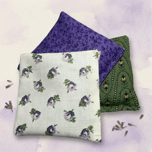 Three lavender sachets with different patterns on a light purple background