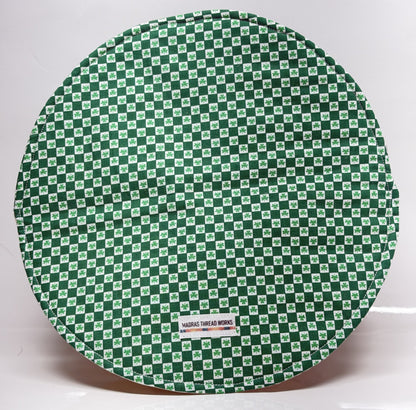 Round green and white checkered mat with a visible brand label on a white background